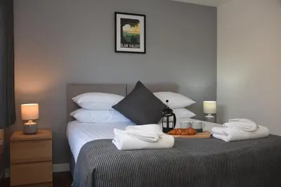 a bedroom with a bed with towels on it at Maen Llwyd in Llanyre