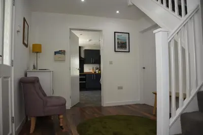 a living room with a staircase and a chair at Maen Llwyd in Llanyre