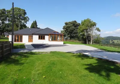 a house with a driveway in front of a yard at Bwthyn Bryn yr Aber in Bala