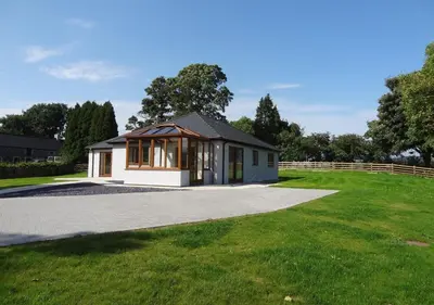 a small house in a field with a driveway at Bwthyn Bryn yr Aber in Bala