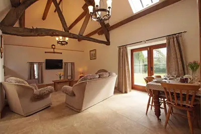 a living room with a table and chairs and a dining room at Degwm in Llanwrin
