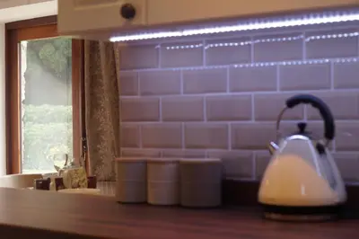 a kitchen counter with a sink and a mirror at Degwm in Llanwrin