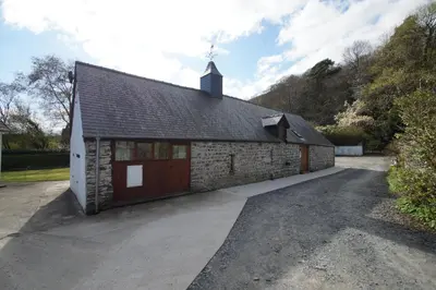 a stone building with a garage at Degwm in Llanwrin