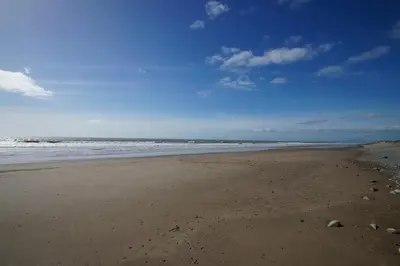 an empty beach with the ocean in the background at Enlli Lodge in Llanddwywe