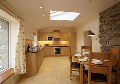 a kitchen with a table and a dining room at Hafod in Llanddwywe