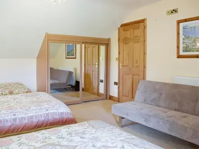 a living room with a couch and a mirror at No 1 Pegraig Draw - Uk6434 in Llanychaiarn