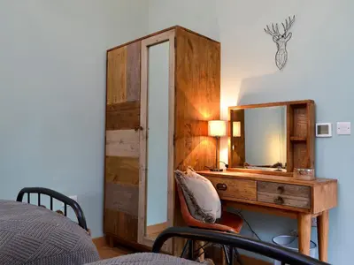 a bedroom with a desk with a mirror and a bed at Maes Merlin in Llanddeusant