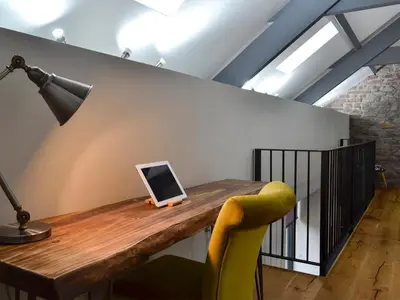 a desk with a laptop computer on top of a wall at Maes Merlin in Llanddeusant
