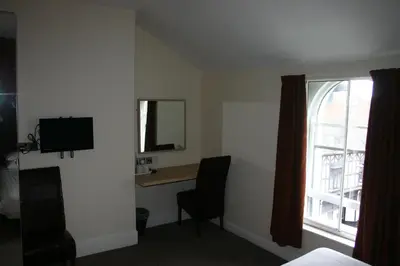 a hotel room with a desk and a window at The Vaults in Shrewsbury