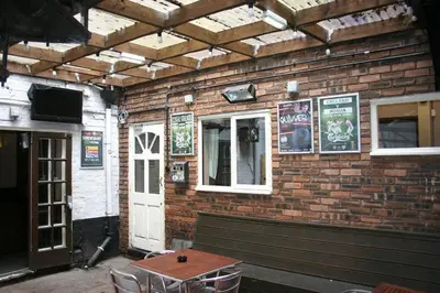 a brick building with a bench and a white door at The Vaults in Shrewsbury