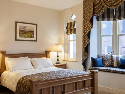 a bedroom with a large bed and two windows at Parkers House Bed & Breakfast in Newtown
