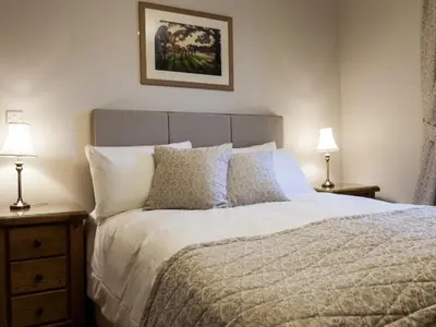 a bedroom with a bed with two night stands and two lamps at Parkers House Bed & Breakfast in Newtown