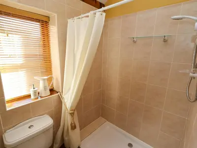 a bathroom with a shower curtain and a toilet at The Old Dairy in Shrewsbury