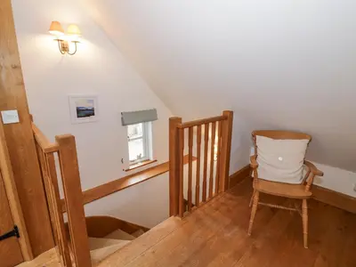 a stair room with a chair and a stair case at The Old Workshop in Church Pulverbatch