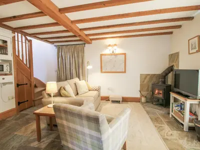 a living room with a couch and a tv at The Old Workshop in Church Pulverbatch