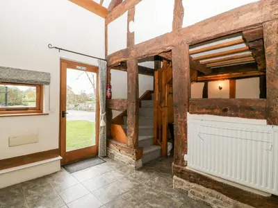 a barn conversion with wooden walls and a door at Stable End in Pembridge