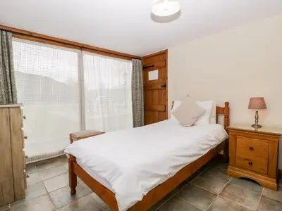 a bedroom with a white bed and a window at Stable End in Pembridge