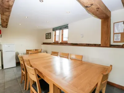 a large dining room with a large wooden table and chairs at The Hop Kiln in Pembridge
