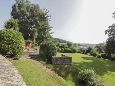 a garden with green grass and bushes and trees at The Croft in Vowchurch