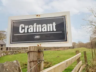 a sign that saysgrant on a wooden fence at Y Bwthyn in Llanbedr