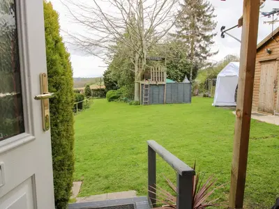 an open door to a yard with a tent at The Log Cabin in Adforton