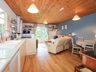 a kitchen and living room with a couch and a table at The Log Cabin in Adforton