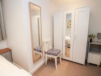 a bedroom with a chair and a mirror at Inglenook in Ludlow