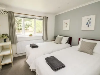 two beds in a room with a window at Inglenook in Ludlow