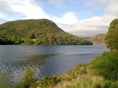 a large body of water with a mountain in the background at Tailor's Cottage in Abbey-Cwmhir