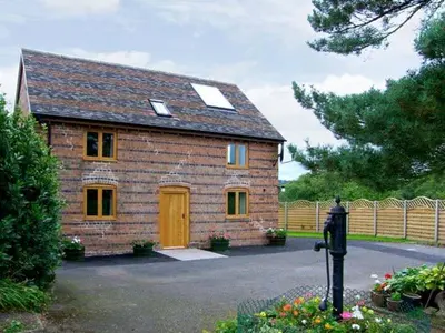 a brick house with a yellow door in a yard at The Old Cider Mill in Farden