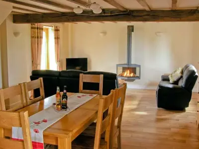 a living room with a table and chairs and a fireplace at The Old Cider Mill in Farden