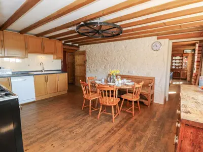 a kitchen and dining room with a table and chairs at The Farmhouse in Ciliau-Aeron