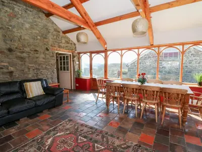 a living room with a table and chairs and a couch at The Farmhouse in Ciliau-Aeron