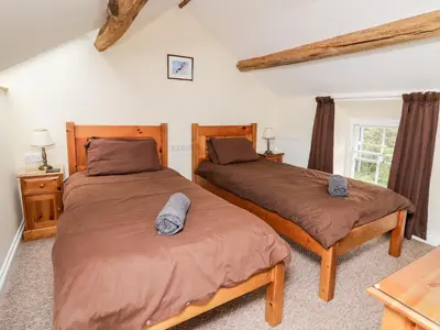 a bedroom with two twin beds and a table at Penlon in Aberystwyth