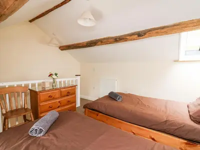 a bedroom with two beds and a dresser at Penlon in Aberystwyth