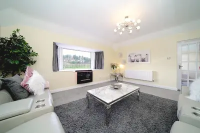 a living room with a couch and a table at Lower Lodge in Cardeston