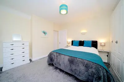 a white bedroom with a bed and a dresser at Lower Lodge in Cardeston