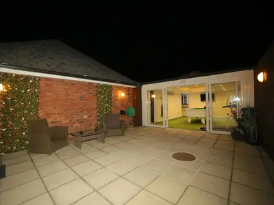 a screened in patio at night with a brick wall at Lower Lodge in Cardeston