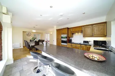 a kitchen with a large counter and chairs in it at Lower Lodge in Cardeston