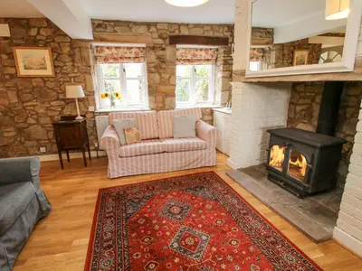a living room with a fireplace and a stove at The Coach House in Ludlow
