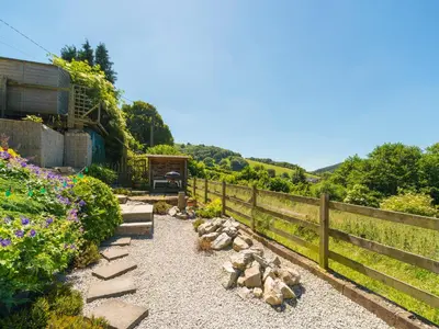 a garden with a fence and a bench and flowers at The Old Chapel in Shelve