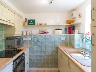 a kitchen with blue tiles on the wall and a sink at The Old Chapel in Shelve