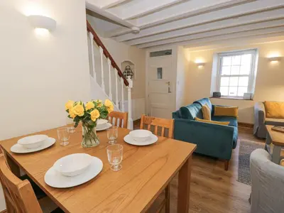 a dining room and living room with a wooden table at Ty Gwyn in Aberdyfi