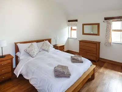a bedroom with a large bed with two towels on it at Beudy in Llangwm