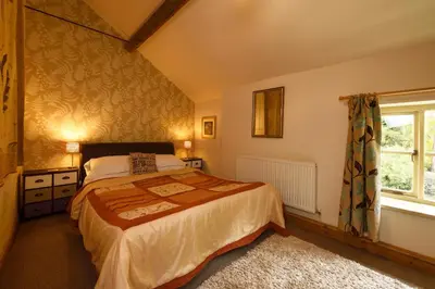 a bedroom with a bed and a window at The Coach House in Oswestry