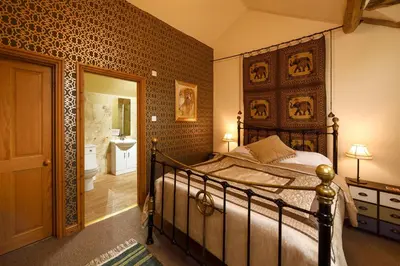 a bedroom with a bed and a bathroom at The Coach House in Oswestry