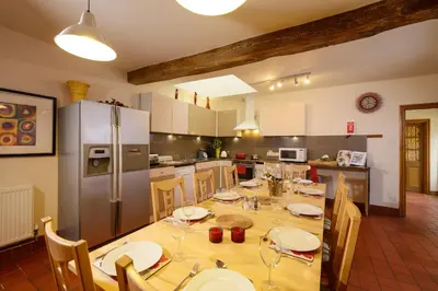 a kitchen with a large wooden table with chairs at The Coach House in Oswestry