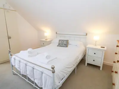 a bedroom with a white bed and two night stands at Cariad Cottage in Cilcennin