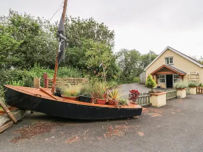 a boat sitting in the driveway of a house at Cariad Cottage in Cilcennin