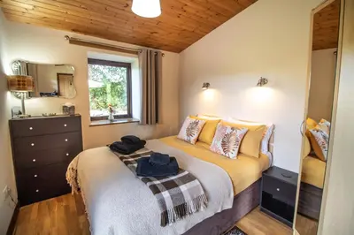 a bedroom with a bed and a window at Sycamore Lodge in Rhayader